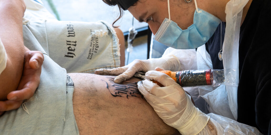 Professionista che realizza tatuaggio stile lettering